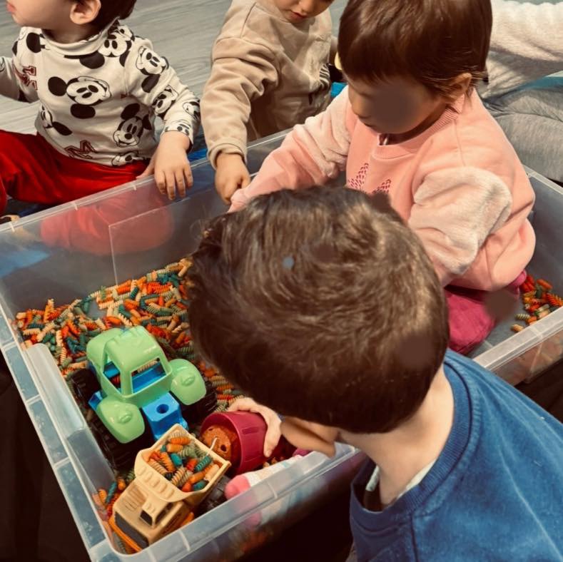 Παιδιά που παίζουν με τα μακαρόνια που έφτιαξαν στο Pasta Messy Play